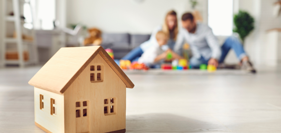 A family in a living room with a model home in front