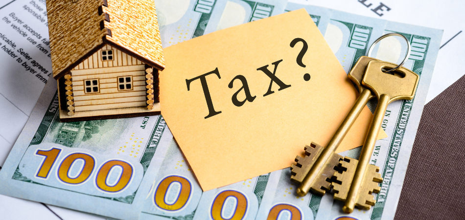 Keys,a paper that says tax, and a model home, on top of money