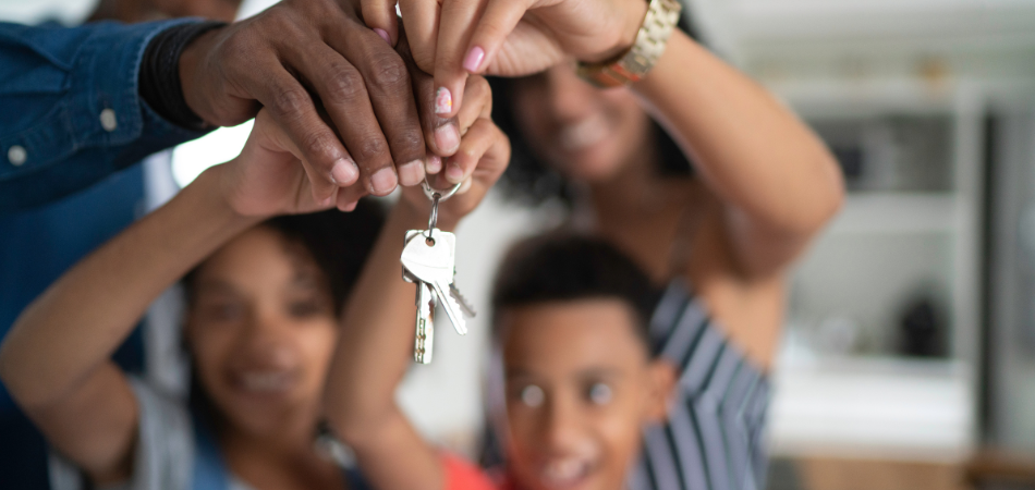A family holding up a house key together